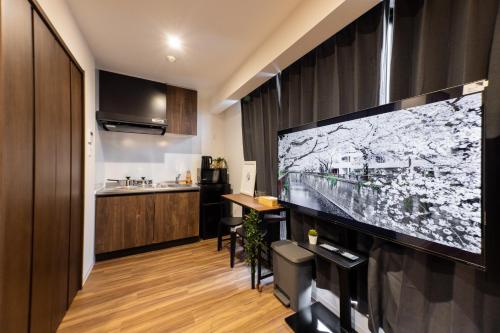 a living room with a large flat screen tv at Sanctuary Residence難波大国Ⅱ in Osaka
