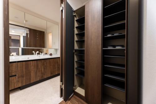 a bathroom with a wooden closet with a sink at Sanctuary Residence難波大国Ⅱ in Osaka
