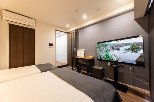 a hotel room with a large flat screen tv at Sanctuary Residence難波大国Ⅱ in Osaka