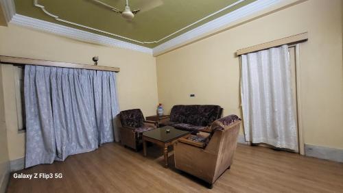 a living room with two chairs and a table at Hotel Sangam in Baharampur