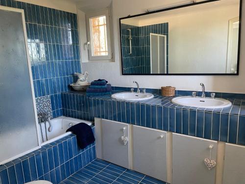 - une salle de bains carrelée de bleu avec deux lavabos et un miroir dans l'établissement Villa Eden, à Tourrettes-sur-Loup