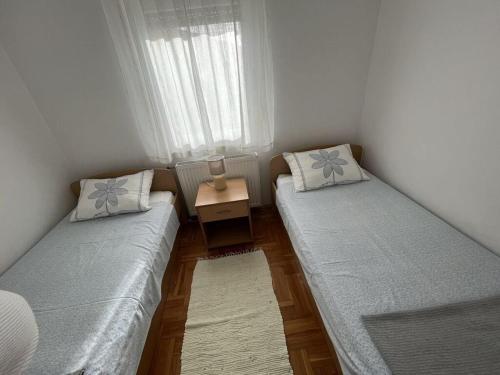 two beds in a small room with a table at Medulin Burle A4 1 in Medulin
