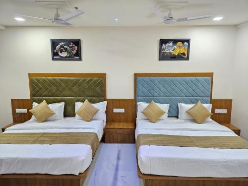 two beds in a room next to each other at Hotel Vivan Inn in Himatnagar