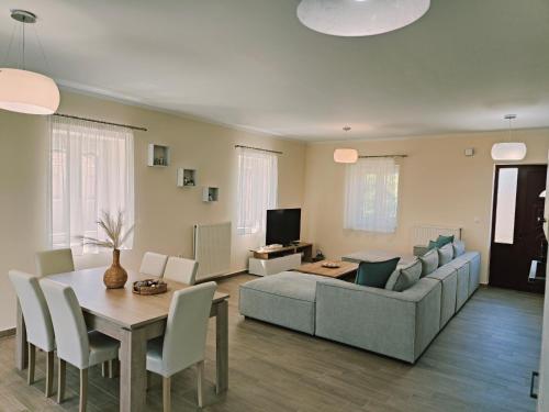 a living room with a couch and a table at Lucy's luxury II in Néa Koútali