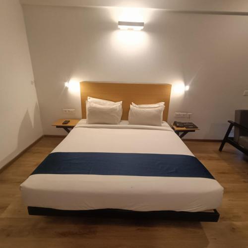 ein Schlafzimmer mit einem großen Bett mit zwei Kissen in der Unterkunft Hotel Somani Wakad in Méribel Village