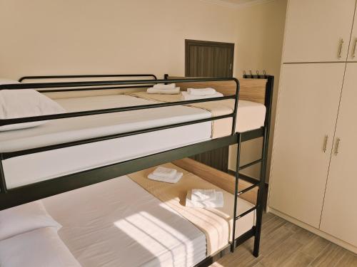 two bunk beds in a room with a kitchen at Lucy's luxury II in Néa Koútali