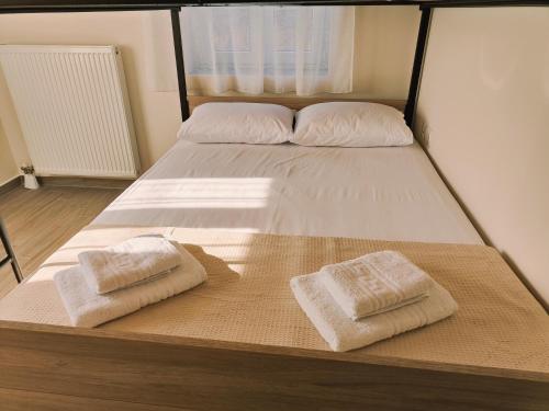 a bed with two towels on top of it at Lucy's luxury II in Néa Koútali