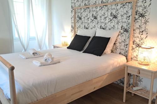 une chambre avec un lit avec une tête de lit en bois dans l'établissement In the heart of Sarlat- Charming & Authentic House, à Sarlat-la-Canéda