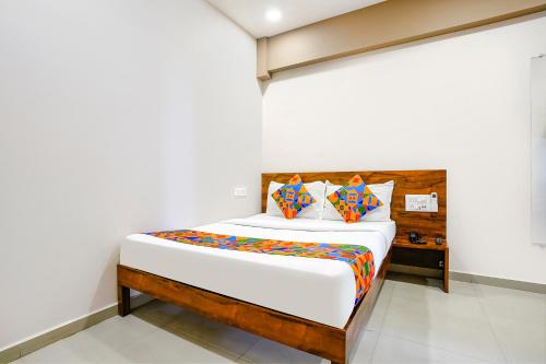 a bedroom with a bed with a wooden headboard at FabHotel Royal Paradise in Bhatha