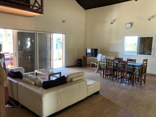 - un salon avec un canapé, une table et des chaises dans l'établissement VILLA RAVOLA - Ambondrona, à Nosy Be