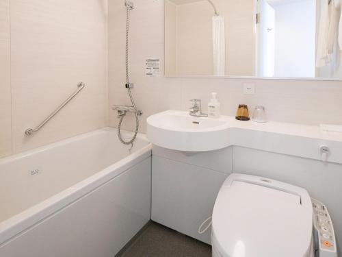 a white bathroom with a toilet and a sink at Vessel Inn Shigamoriyama Station in Moriyama
