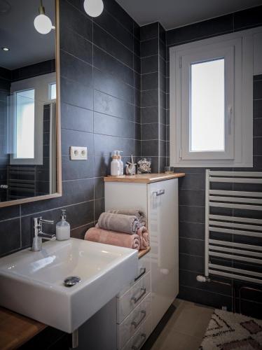 une salle de bain avec un lavabo et un miroir dans l'établissement Venez Chez Vous Villa Singa, à Annecy