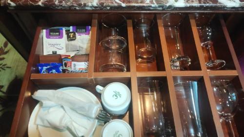 a wooden shelf with dishes and other items on it at SkyCity Hotel Gurgaon in Gurgaon