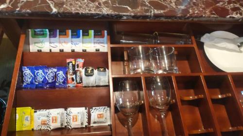 a shelf with wine glasses on a table at SkyCity Hotel Gurgaon in Gurgaon