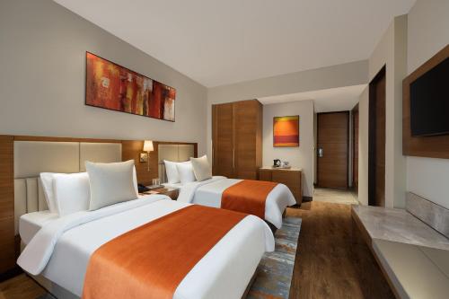 a hotel room with two beds and a flat screen tv at Fortune Park, East Delhi - Member ITC Hotels' Group in New Delhi