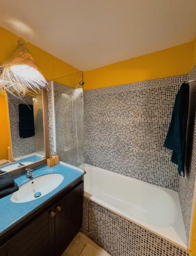 une salle de bain avec un lavabo et une baignoire dans l'établissement Bali Chic : Vue mer à Cannes, à Cannes