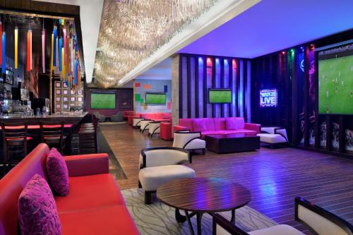 a bar with pink couches and a table and a bar at Marriott Hotel Al Jaddaf, Dubai in Dubai