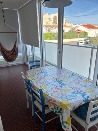 une table et des chaises dans une pièce avec une fenêtre dans l'établissement Le ROS ÉDEN, à Saint-Hilaire-de-Riez