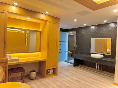 W łazience znajduje się umywalka i lustro. w obiekcie Sokcho Mir Hotel w mieście Sokcho