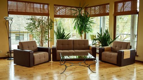 a living room with two couches and a coffee table at LVM tūrisma un atpūtas centrs "Ezernieki" in Meirāni