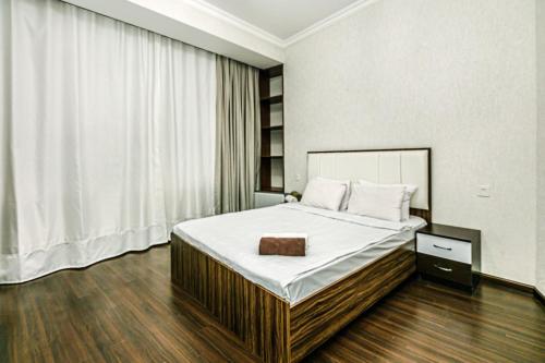 1 dormitorio con 1 cama grande con sábanas blancas en City Centre DeLuxe en Baku