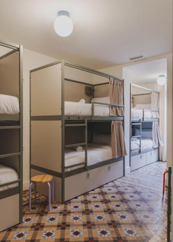 a bedroom with two bunk beds and a rug at Piulet Hostel in Barcelona