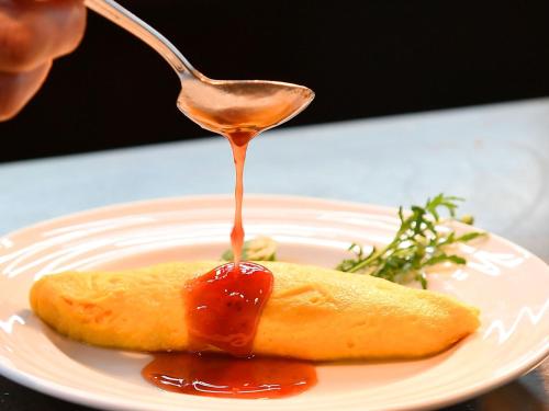 una cuchara con salsa en un trozo de comida en un plato en Hotel Plaza Kobe en Kobe