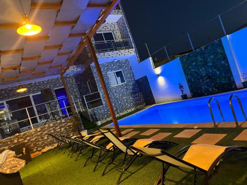 a patio with chairs and a swimming pool at night at Pereira lounge bar in Praia