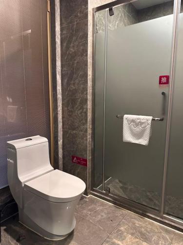 a bathroom with a toilet and a shower at MIZPARTON HOTEL - Heshan Xinhua City Store in Jiangmen