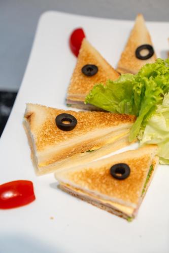 a white plate with three slices of food with faces on it at 3T Hotel Hanoi in Hanoi