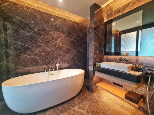 a bathroom with a white tub and a sink at Imperial Luxury Suites KLCC by Moonway in Kuala Lumpur