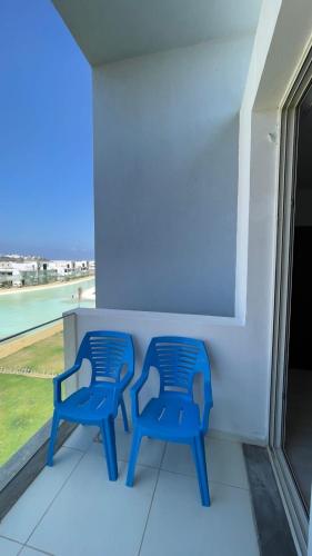 two blue chairs sitting on a balcony with a window at Fouka bay chalet at north coast, Egypt in Marsa Matruh