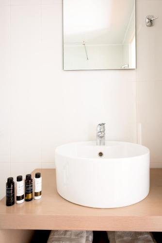 a bathroom with a white sink and a mirror at Jasmin & Olives in Érfoi