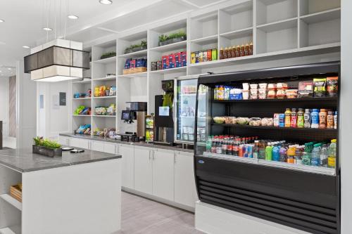 a kitchen with a counter with a refrigerator at EVEN Hotel Austin Uptown near the Domain by IHG in Austin