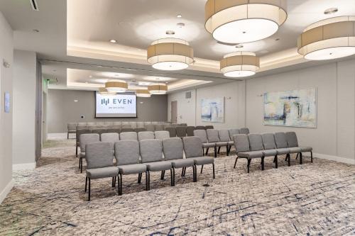 a conference room with chairs and a projection screen at EVEN Hotel Austin Uptown near the Domain by IHG in Austin