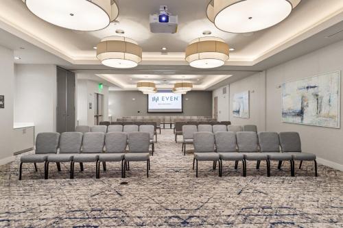 a conference room with chairs and a projection screen at EVEN Hotel Austin Uptown near the Domain by IHG in Austin