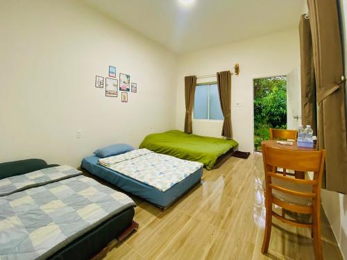 2 camas en una habitación con mesa y silla en Mộc Lam Homestay, en Xóm Chum Găng