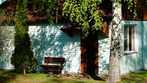 TolokunにあるДом для відпочинку, у парку, на березі моряの青い家の外に座る木製椅子