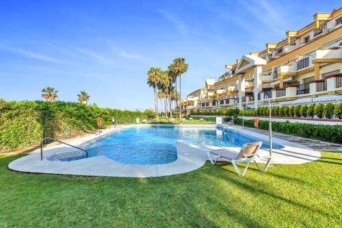 Romana Playa beach apartment 723 in Elviria, Marbella في مربلة: مسبح في ساحة بجانب مبنى