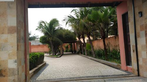 um corredor vazio com palmeiras e um edifício em Hotel Navegantes Beach em Fortaleza