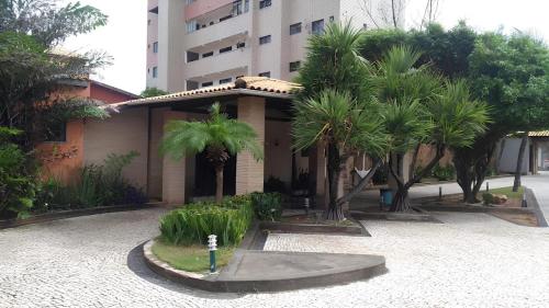 a house with palm trees in front of a building at Hotel Navegantes Beach in Fortaleza