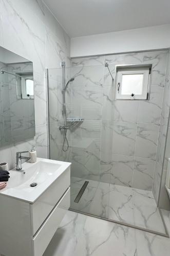 baño blanco con ducha y lavamanos en Zain Apartment en Craiova
