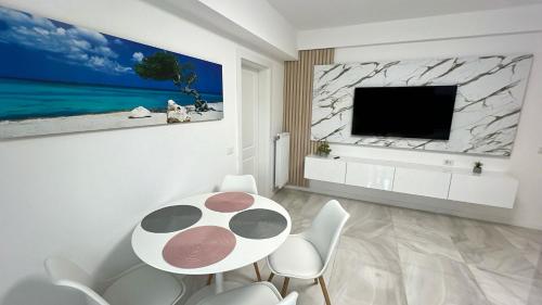 sala de estar con mesa, sillas y TV en Zain Apartment en Craiova