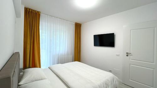 1 dormitorio con 1 cama y TV en la pared en Zain Apartment en Craiova