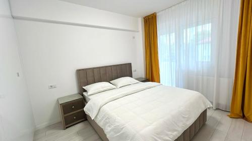 Un dormitorio con una cama grande y una ventana en Zain Apartment en Craiova