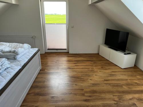 a bedroom with a bed and a flat screen tv at Ferienwohnung Seeblick in Retgendorf
