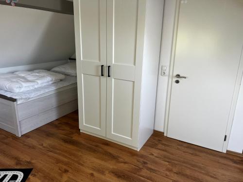 a small bedroom with a bed and white cabinets at Ferienwohnung Seeblick in Retgendorf