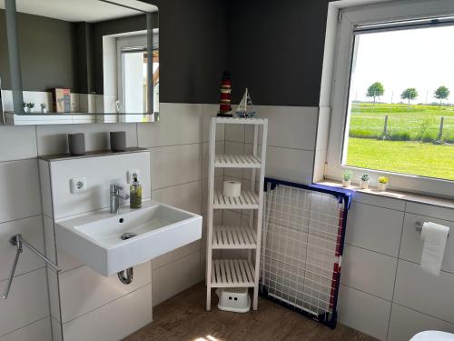 a bathroom with a sink and a mirror and a window at Ferienwohnung Seeblick in Retgendorf