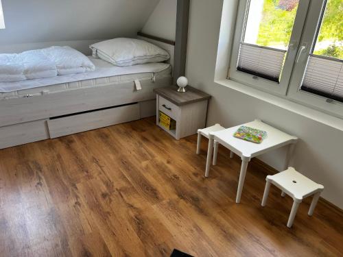 a small bedroom with a bed and a table at Ferienwohnung Seeblick in Retgendorf