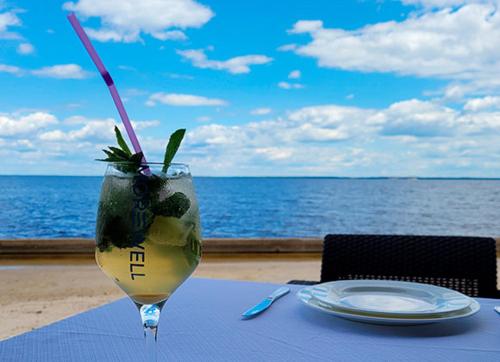 a drink on a table with a view of the ocean at Morewell in Tolokun